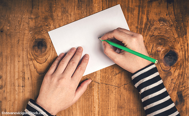 Hand schreibt auf Papier