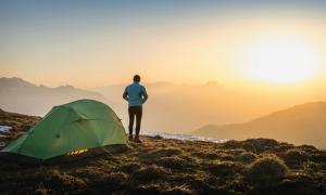 Mann auf Berg beim Sonnenaufgang