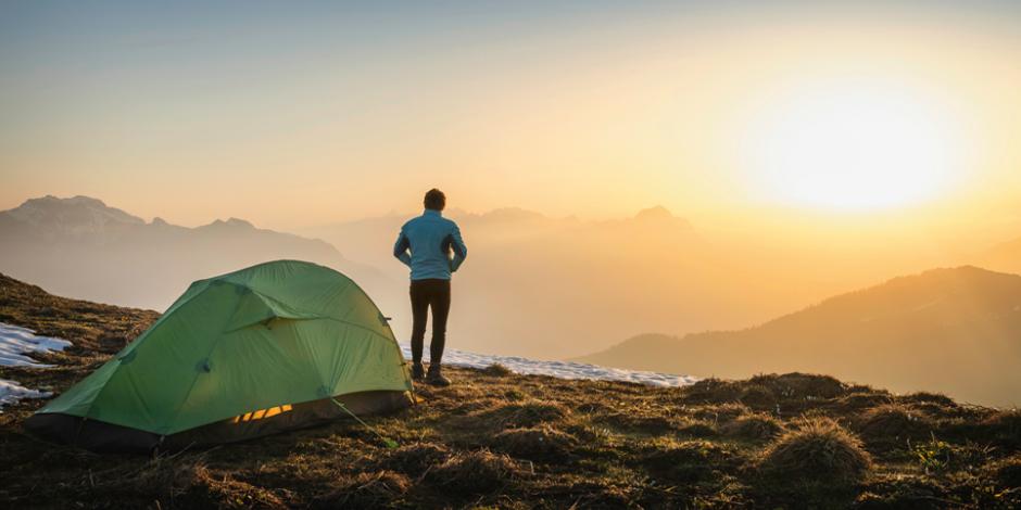 Mann auf Berg beim Sonnenaufgang